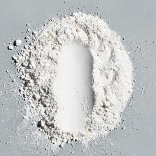 White powder in the shape of a footprint on a gray surface.